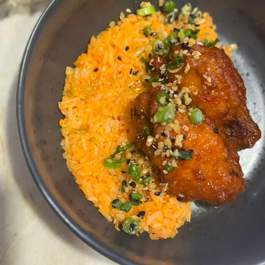 Glazed crispy chicken over spicy gochujang fried rice — Korean-American fusion by Coach Cal