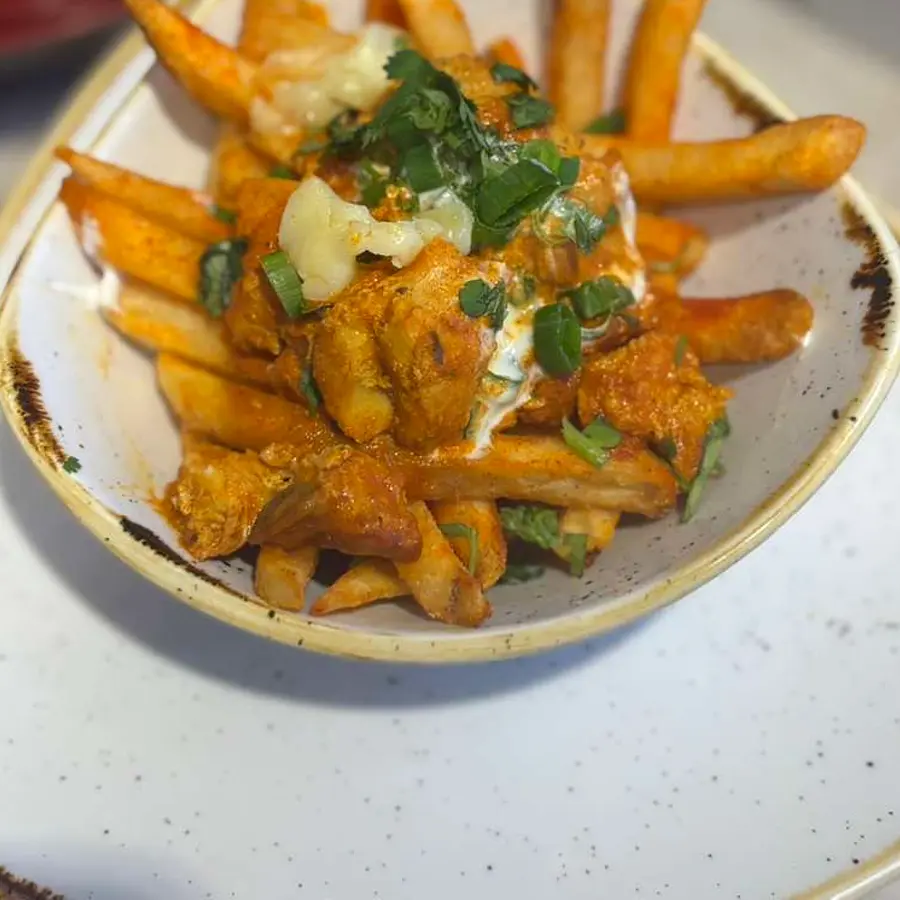 Curry tikka chicken loaded fries with yogurt and cilantro — fusion plate by Bay Area chef Coach Cal