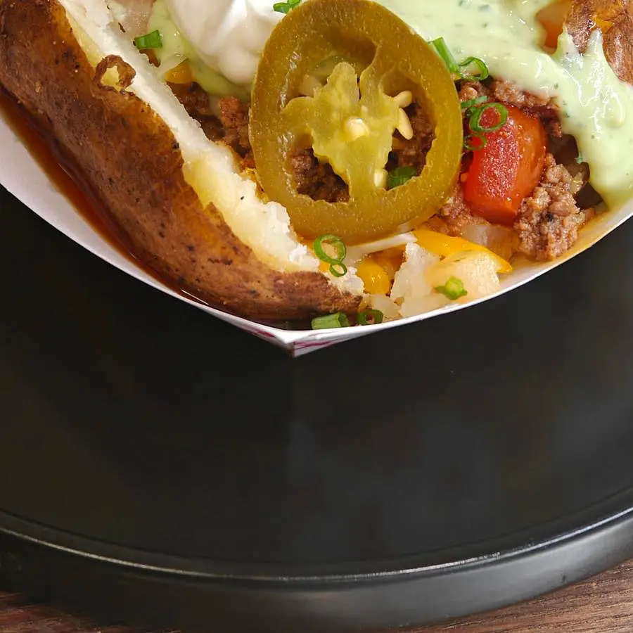 Loaded chili-cheese baked potato with jalapeños and avocado crema — Coach Cal comfort food