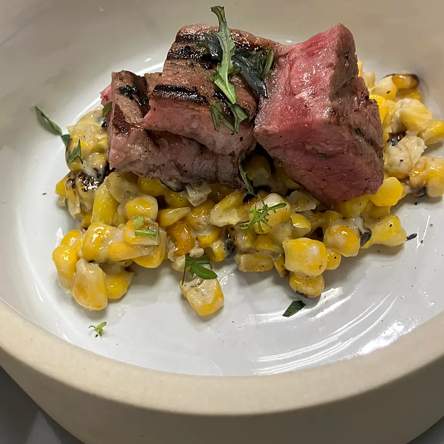 Grilled steak medallions on charred creamed corn — fine-dining plating by Bay Area chef Coach Cal
